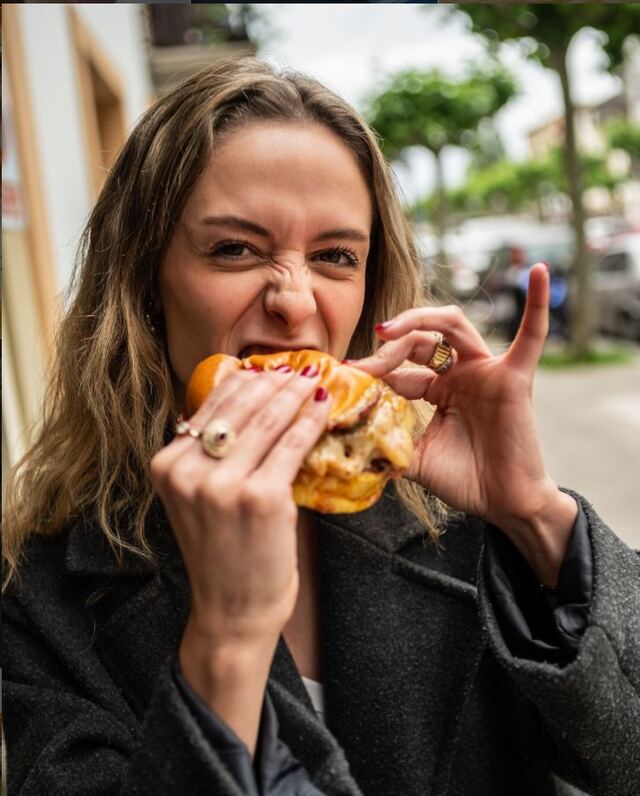 Clienta disfrutando de una hamburguesa Holy en la calle